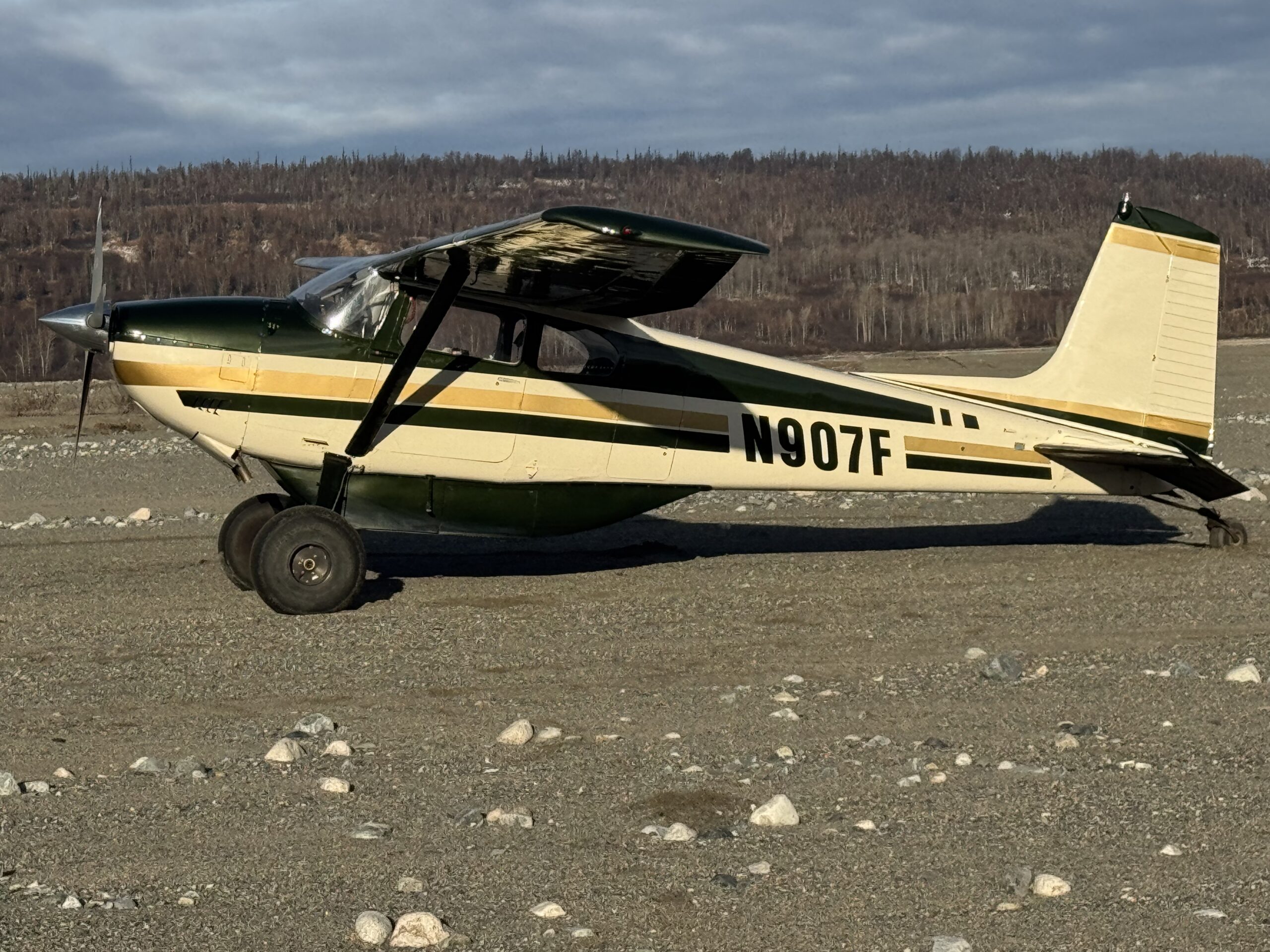 The Fly 907 Airplane in on the ground in front of some Alaskan Mountains